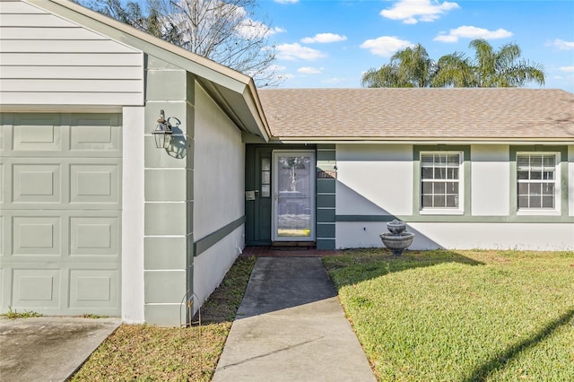 doorway to property featuring a garage and a lawn