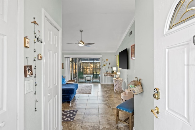 entryway featuring ceiling fan, crown molding, vaulted ceiling, and tile patterned flooring