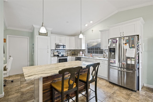 kitchen featuring white cabinets, decorative light fixtures, stainless steel appliances, and lofted ceiling