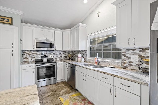 kitchen featuring appliances with stainless steel finishes, light stone counters, crown molding, sink, and white cabinets