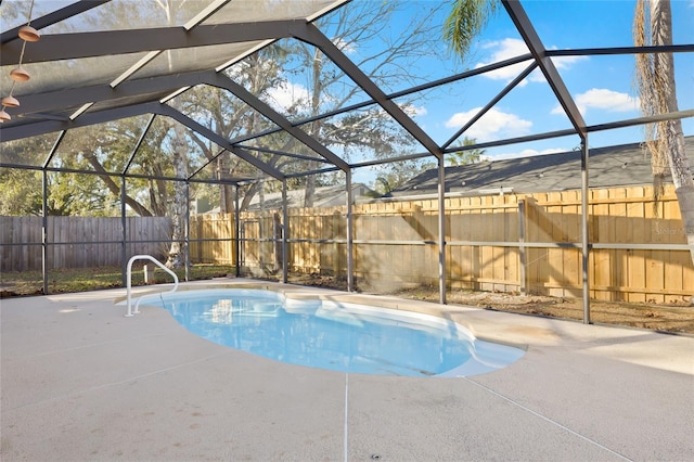 view of pool featuring glass enclosure and a patio area