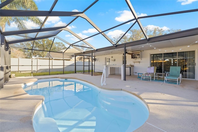 view of pool featuring a patio area, ceiling fan, area for grilling, and glass enclosure