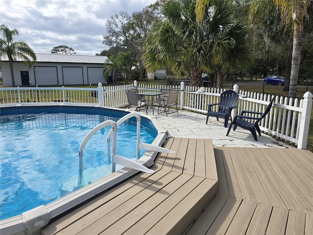 view of pool featuring a garage and an outdoor structure