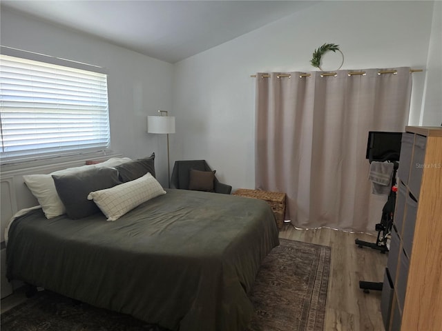 bedroom featuring lofted ceiling and dark hardwood / wood-style floors