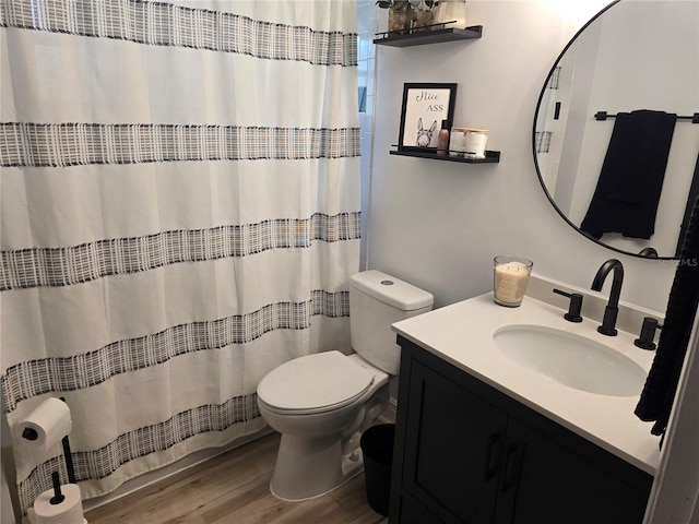 bathroom featuring wood-type flooring, vanity, and toilet