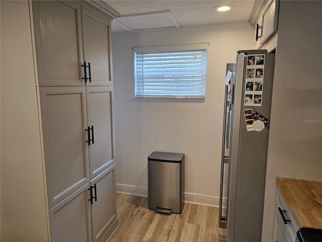 kitchen with stainless steel fridge, light wood-type flooring, and gray cabinets