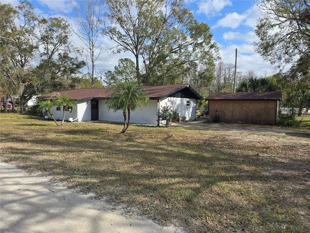 view of home's exterior with a lawn and an outdoor structure