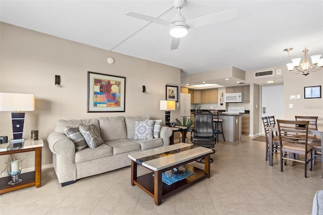 living room with ceiling fan with notable chandelier