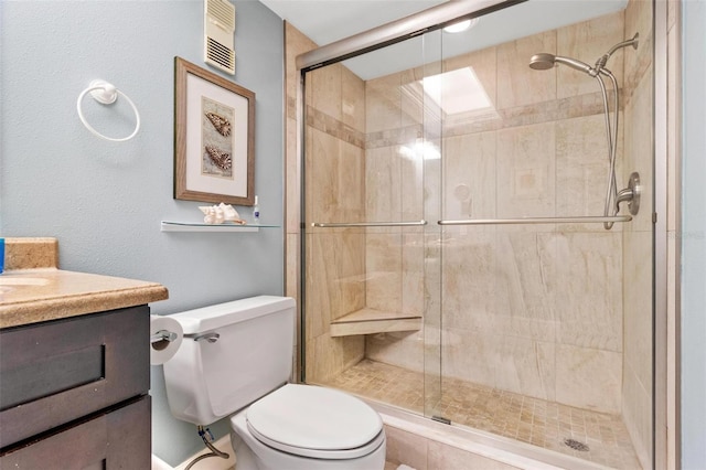 bathroom with vanity, toilet, and a shower with door