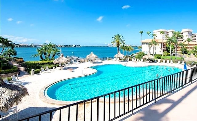 view of pool with a water view and a patio