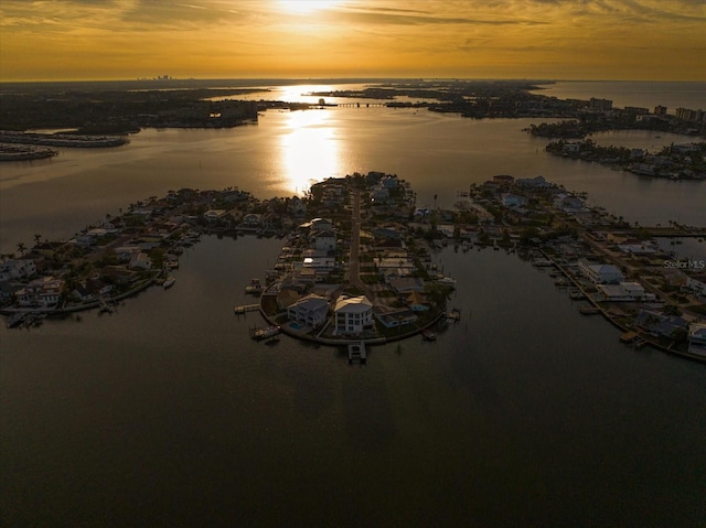 aerial view at dusk featuring a water view