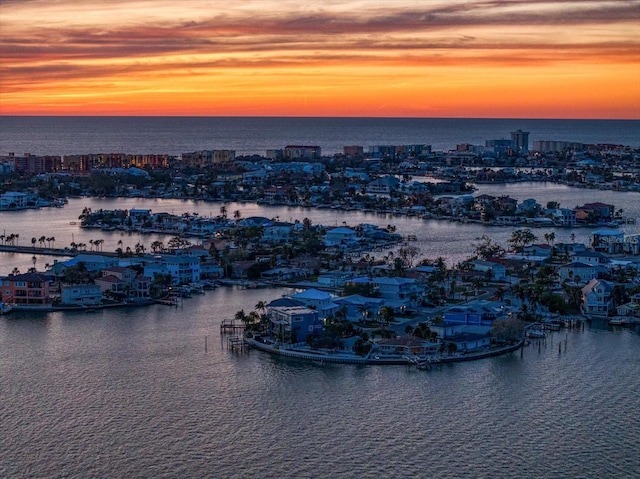 aerial view at dusk featuring a water view