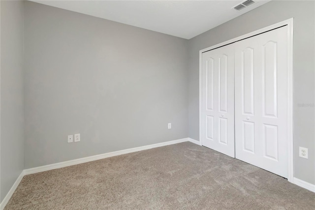 unfurnished bedroom with light carpet and a closet