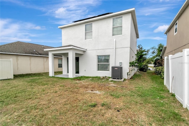 back of property featuring a lawn, central AC, and a patio