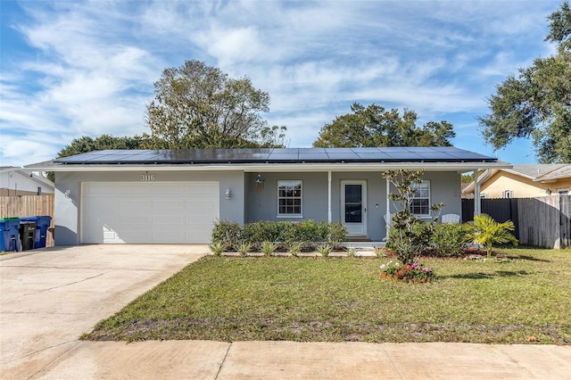 single story home featuring covered porch, solar panels, a garage, and a front lawn