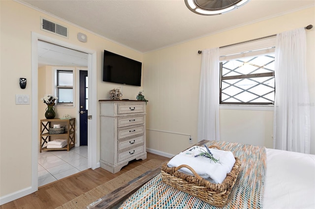 bedroom with crown molding and light wood-type flooring