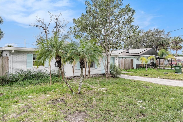 ranch-style house with a front lawn and solar panels