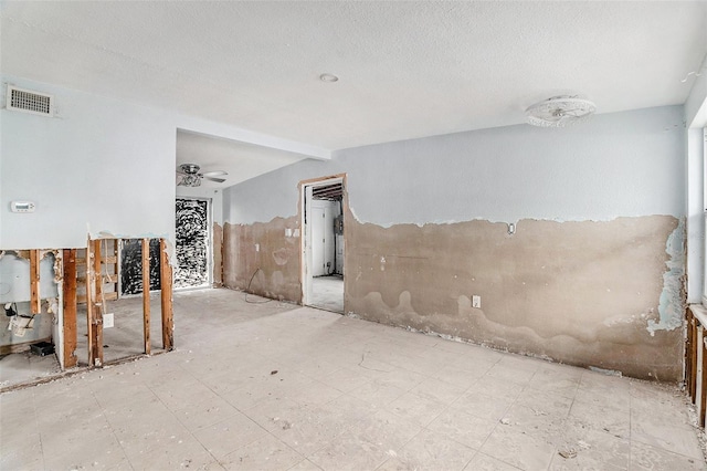 empty room featuring beamed ceiling and ceiling fan