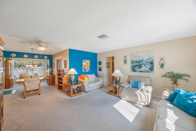 carpeted living room featuring a textured ceiling and ceiling fan