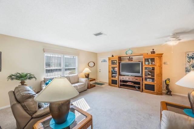 living room with a textured ceiling, ceiling fan, and carpet