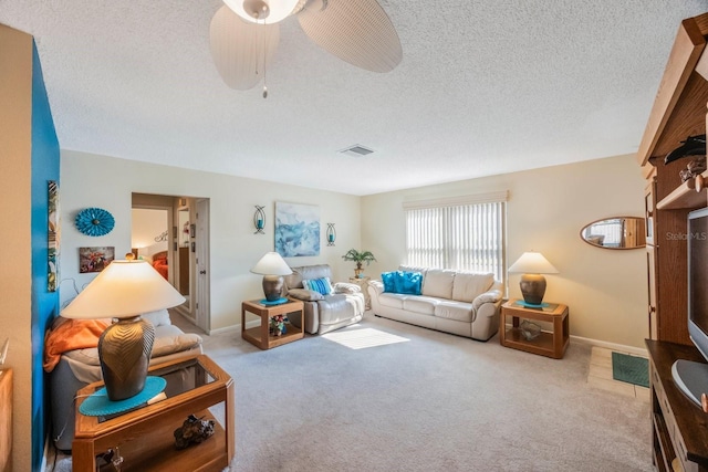 carpeted living room featuring a textured ceiling and ceiling fan