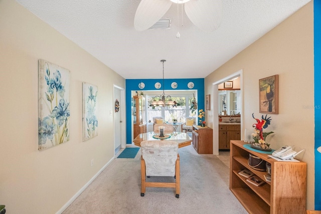 sitting room featuring sink, ceiling fan with notable chandelier, light carpet, and a textured ceiling