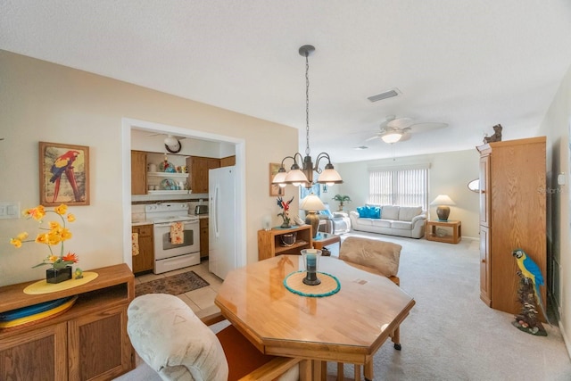 carpeted dining space with ceiling fan with notable chandelier