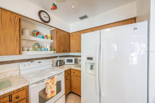 kitchen with white appliances, light tile patterned flooring, and decorative backsplash