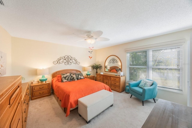 carpeted bedroom with a textured ceiling and ceiling fan