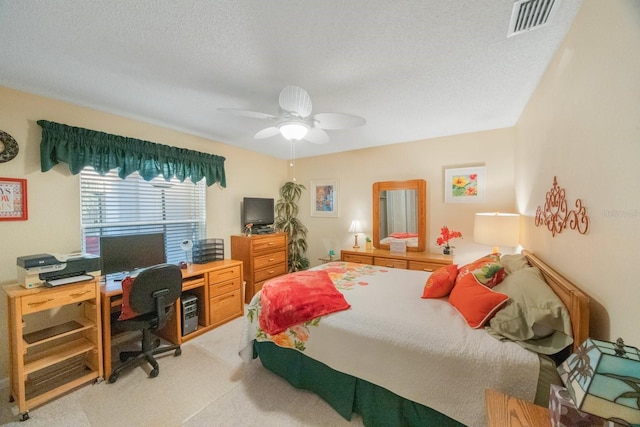 carpeted bedroom with a textured ceiling and ceiling fan