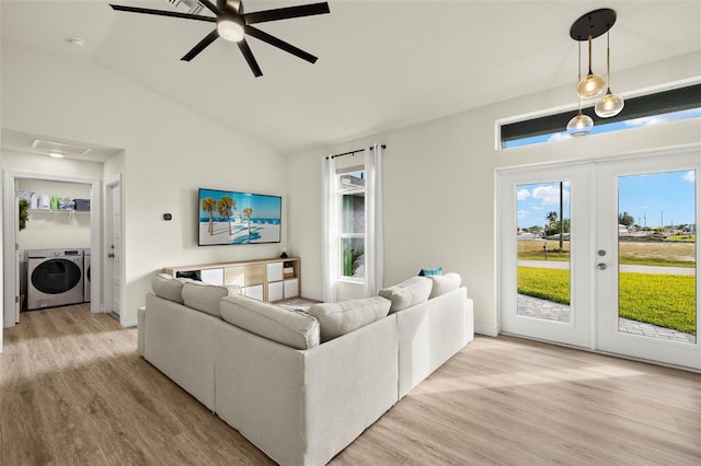 living room with french doors, light wood-type flooring, ceiling fan, independent washer and dryer, and lofted ceiling