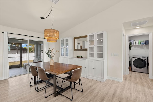 dining area featuring lofted ceiling, independent washer and dryer, and light wood-type flooring