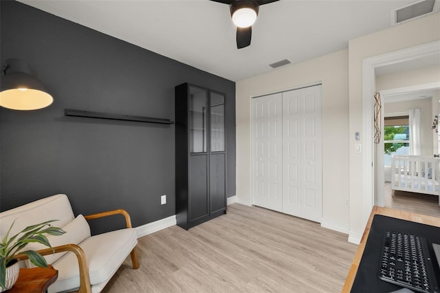 sitting room with ceiling fan and light hardwood / wood-style floors