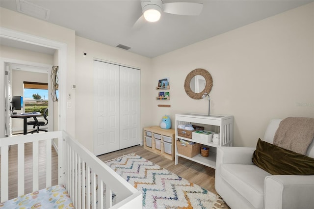 bedroom featuring ceiling fan, a closet, and light wood-type flooring