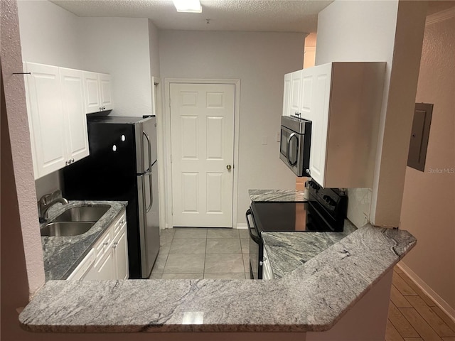 kitchen with kitchen peninsula, electric panel, white cabinetry, and black range with electric stovetop