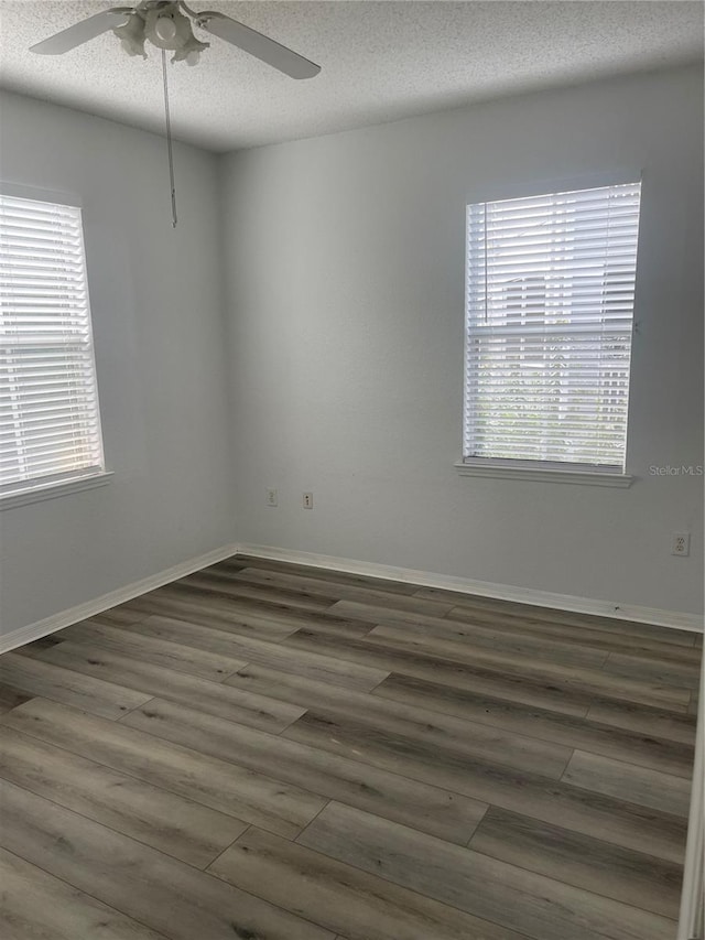 unfurnished room featuring ceiling fan, dark hardwood / wood-style floors, and a textured ceiling