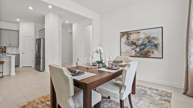 dining area featuring light tile patterned floors and sink