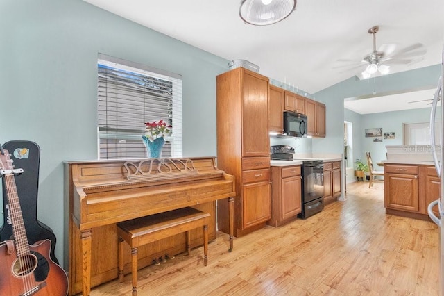 kitchen with ceiling fan, vaulted ceiling, black appliances, and light hardwood / wood-style flooring