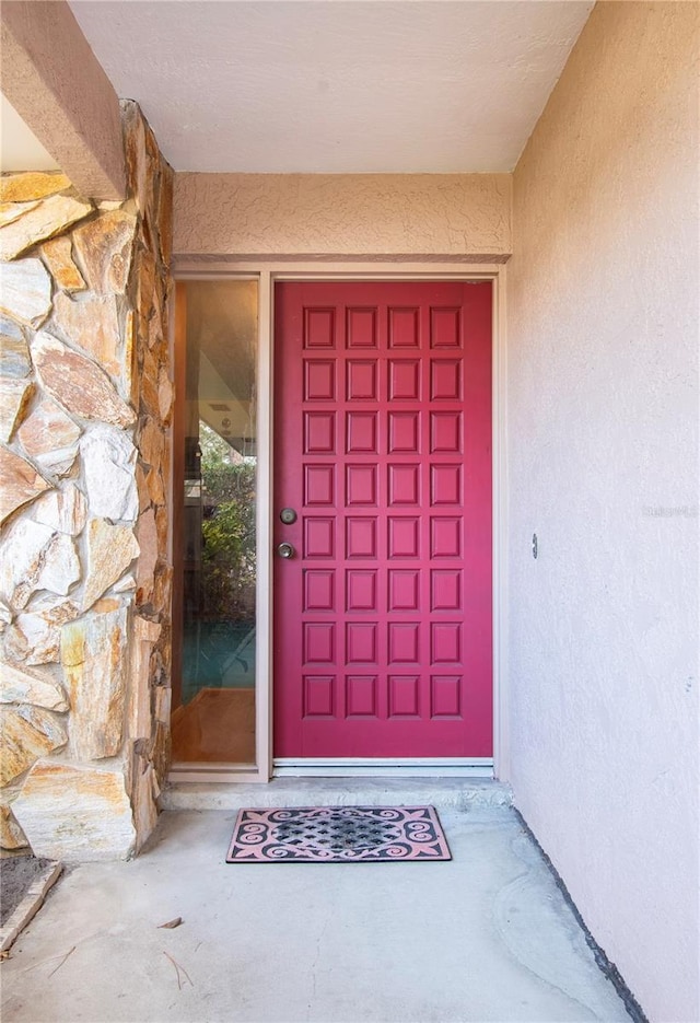 entrance to property featuring stucco siding