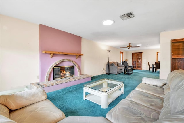 carpeted living room featuring ceiling fan and a fireplace