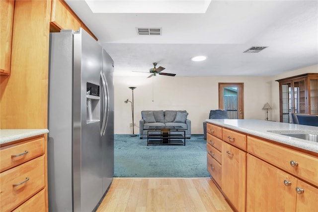 kitchen with stainless steel refrigerator with ice dispenser, light hardwood / wood-style flooring, and ceiling fan