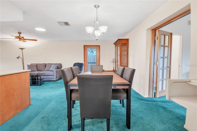 carpeted dining room featuring ceiling fan with notable chandelier