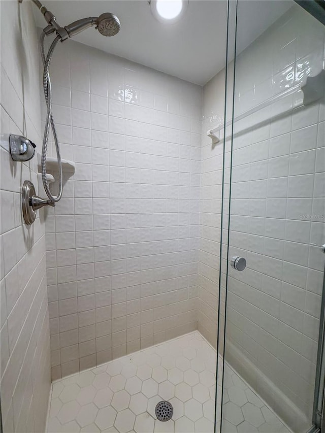 bathroom featuring a tile shower and tile patterned floors