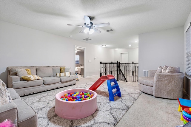 living room featuring ceiling fan and a textured ceiling