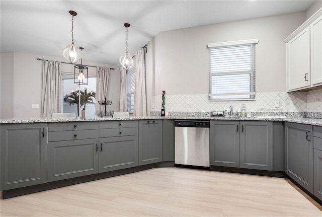 kitchen featuring pendant lighting, dishwasher, backsplash, gray cabinets, and white cabinetry