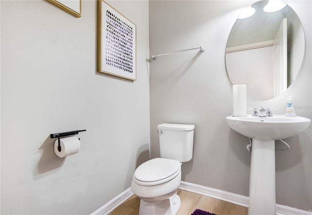 bathroom with hardwood / wood-style flooring and toilet