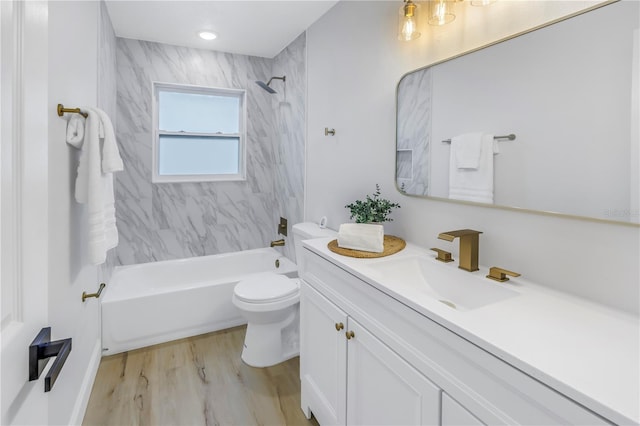 full bathroom with tiled shower / bath, wood-type flooring, vanity, and toilet