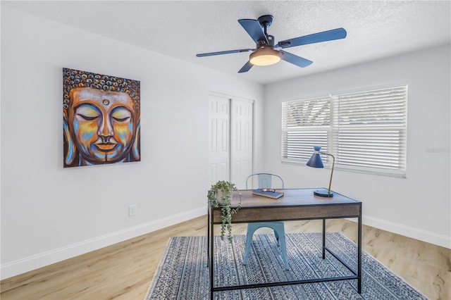 office area featuring wood-type flooring, ceiling fan, and a textured ceiling