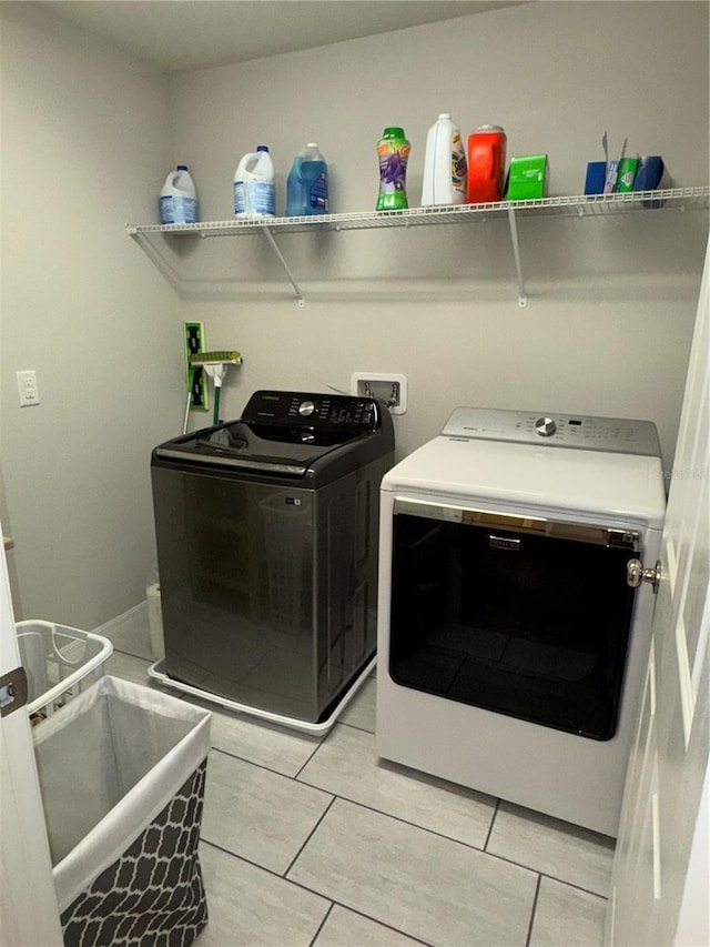 laundry area featuring light tile patterned flooring and separate washer and dryer