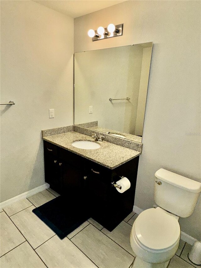 bathroom featuring vanity, tile patterned floors, and toilet